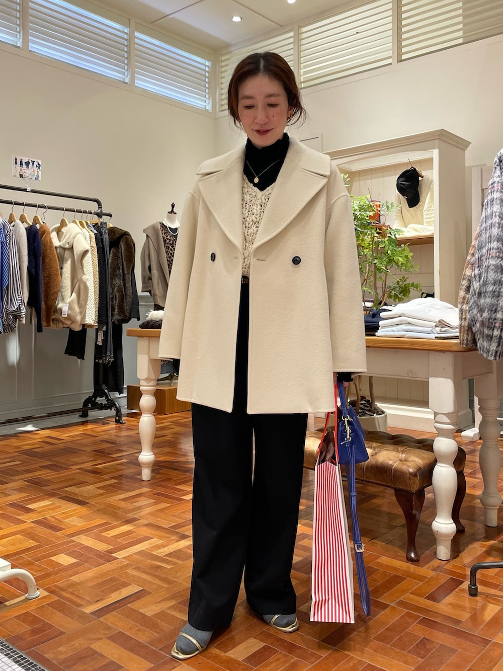 ブラック系のTシャツ/カットソー、ホワイト系のニット/セーター、ホワイト系のダッフルコートを着用したレディースの冬コーディネートの5枚目の写真