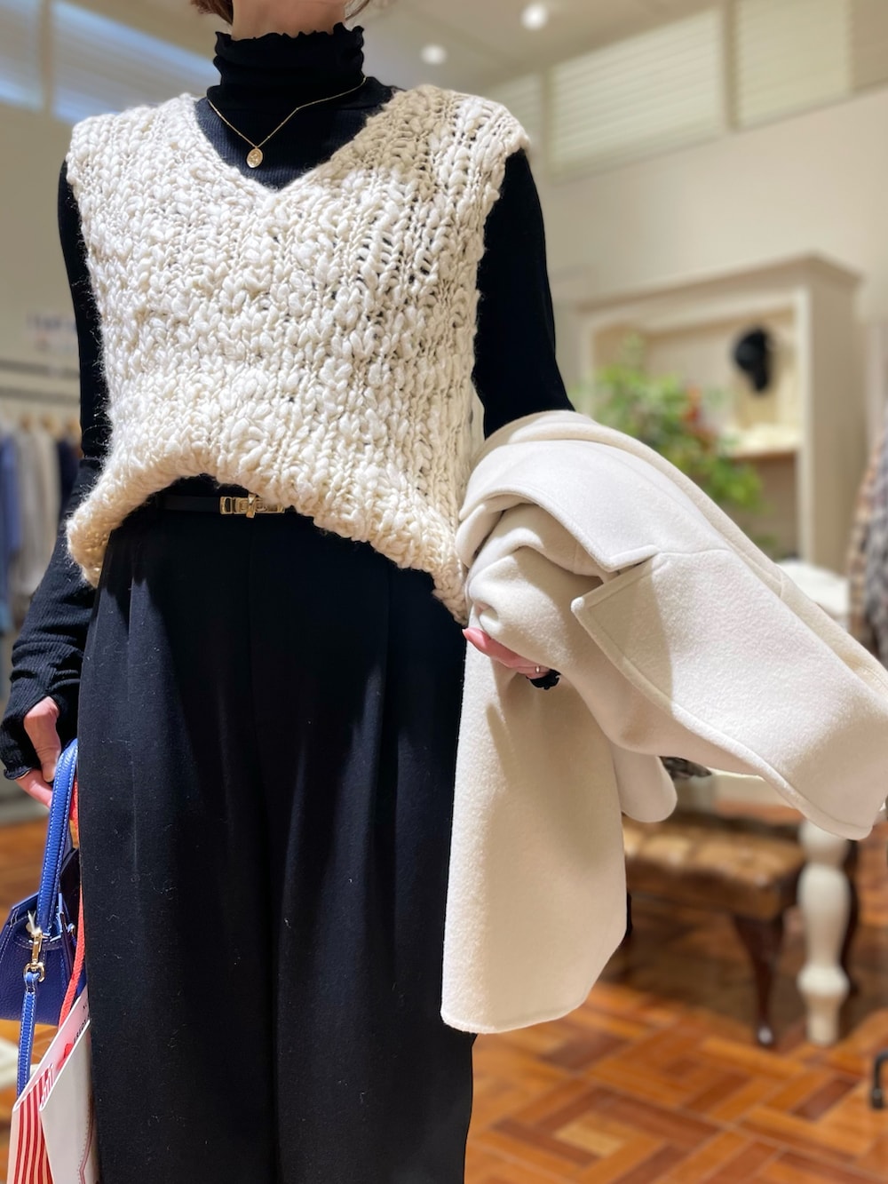 ブラック系のTシャツ/カットソー、ホワイト系のニット/セーター、ホワイト系のダッフルコートを着用したレディースの冬コーディネートの7枚目の写真