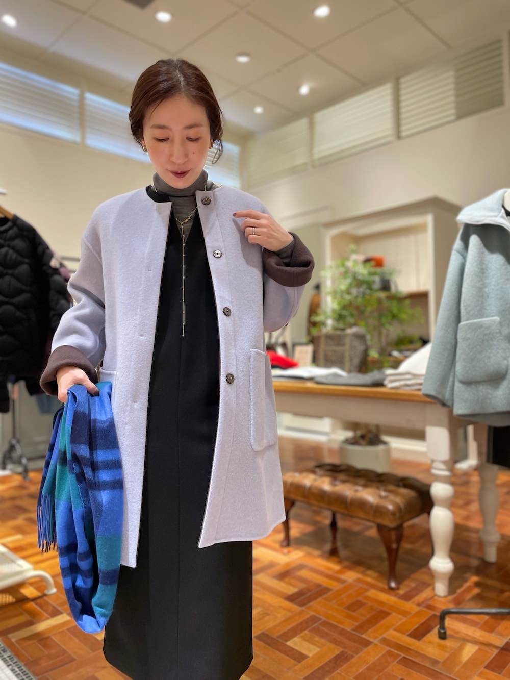 ブラウン系のノーカラーコート、ブラック系のワンピース、グレー系のニット/セーターを着用したレディースの冬コーディネートの4枚目の写真