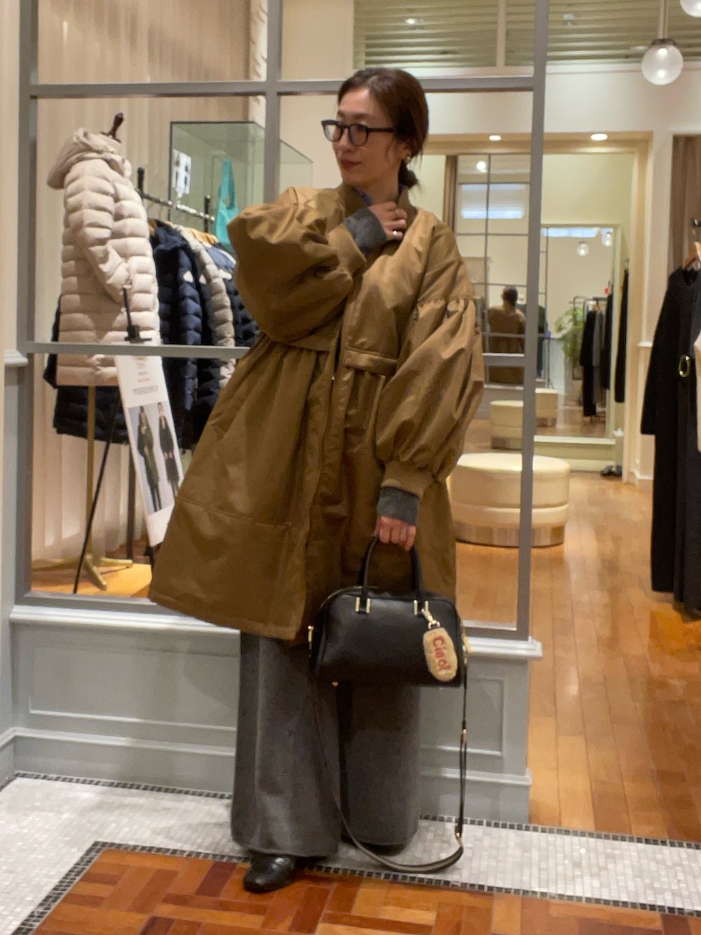 イエロー系のその他アウター、ブルー系のシャツ/ブラウス、グレー系のカーディガン/ボレロを着用したレディースの冬コーディネートの2枚目の写真