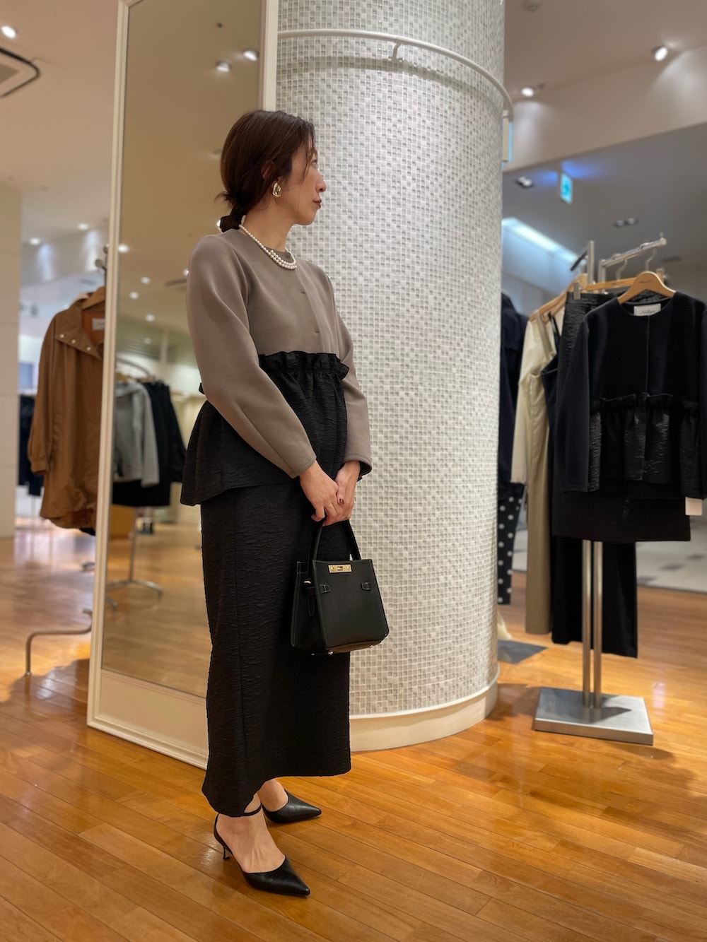 グリーン系のブルゾン、ブラック系のスカート、ブラック系のショルダーバッグを着用したレディースの秋コーディネートの5枚目の写真