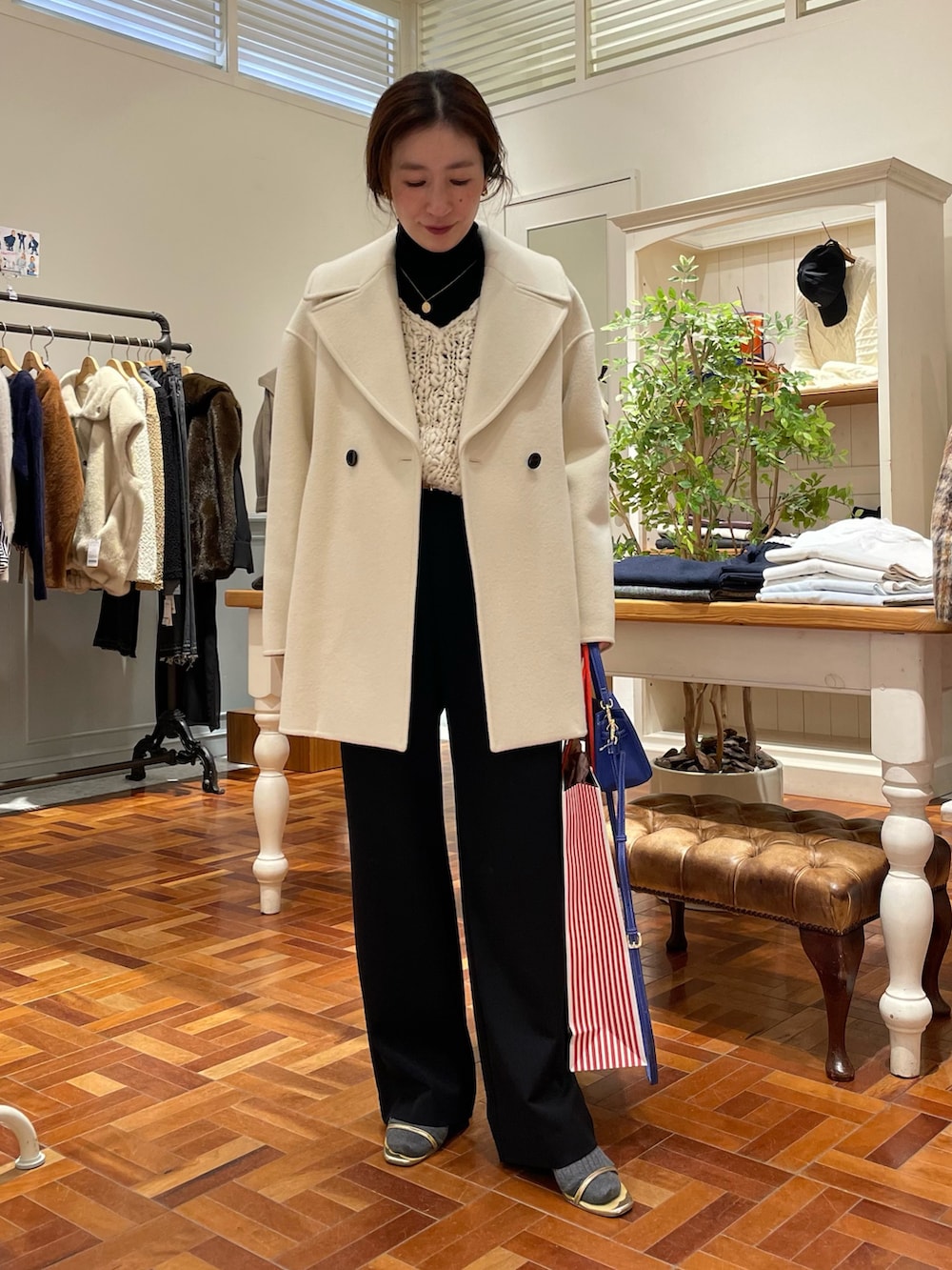 ブラック系のTシャツ/カットソー、ホワイト系のニット/セーター、ホワイト系のダッフルコートを着用したレディースの冬コーディネートの2枚目の写真