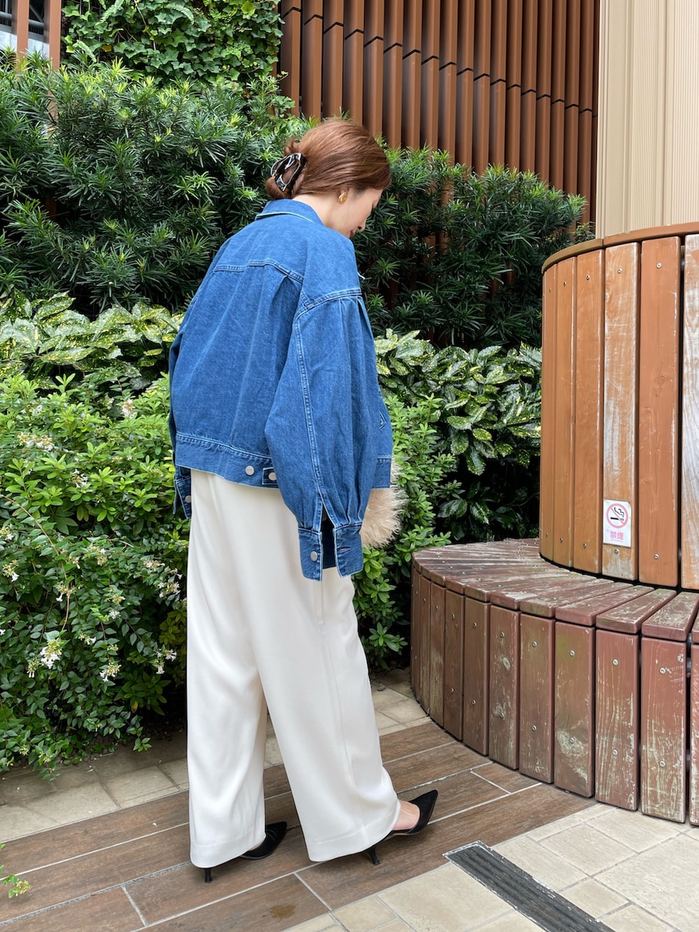 ブルー系のデニムジャケット、ベージュ系のショルダーバッグ、ホワイト系のその他パンツを着用したレディースの秋コーディネートの6枚目の写真