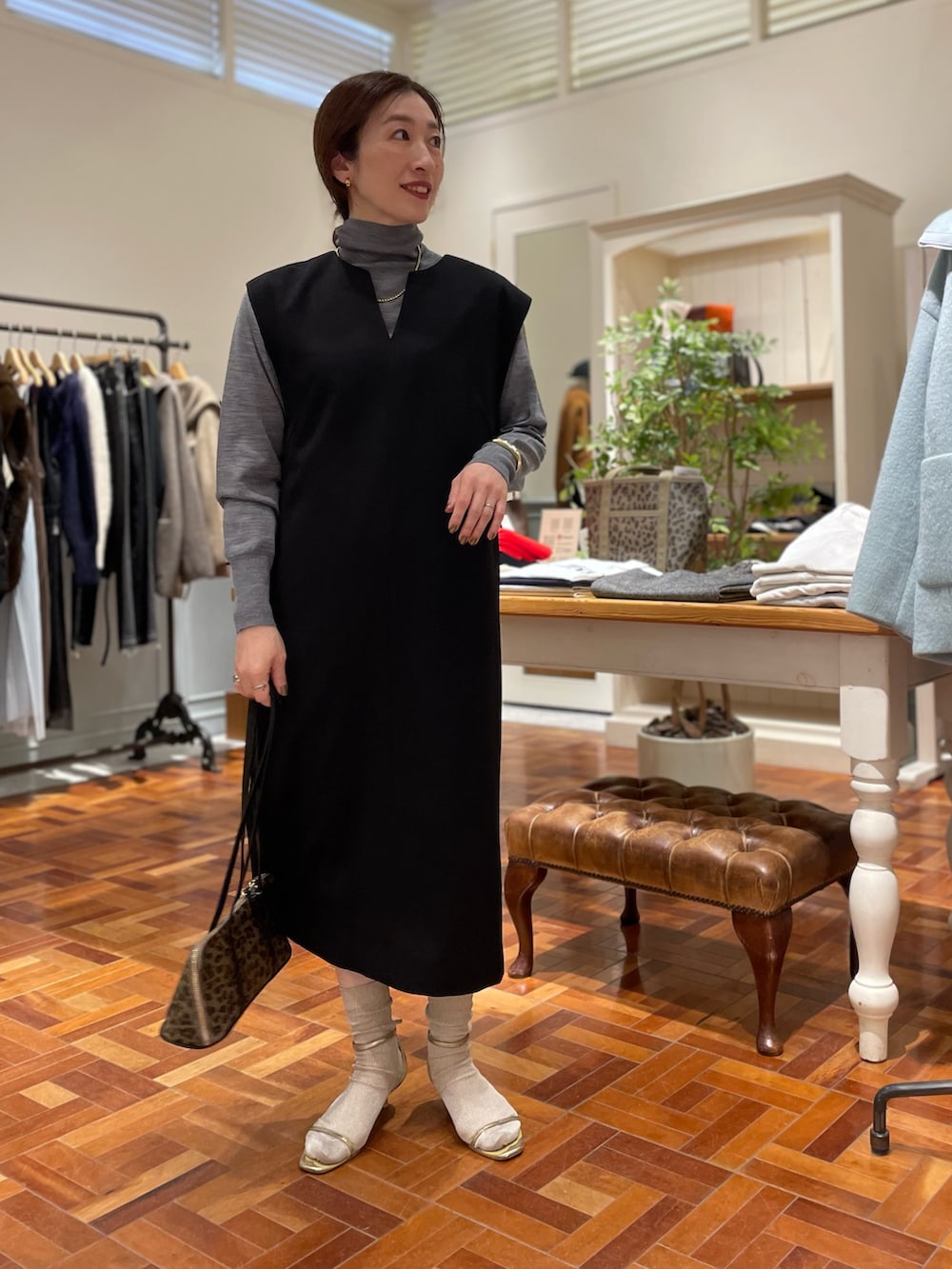 ブラック系のワンピース、グレー系のニット/セーター、ベージュ系のショルダーバッグを着用したレディースの冬コーディネートの8枚目の写真