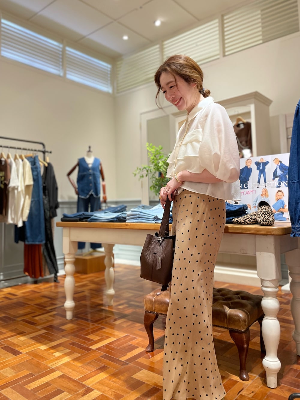 ホワイト系のシャツ/ブラウス、ブラウン系のスカート、ブラウン系のショルダーバッグを着用したレディースの秋コーディネートの2枚目の写真