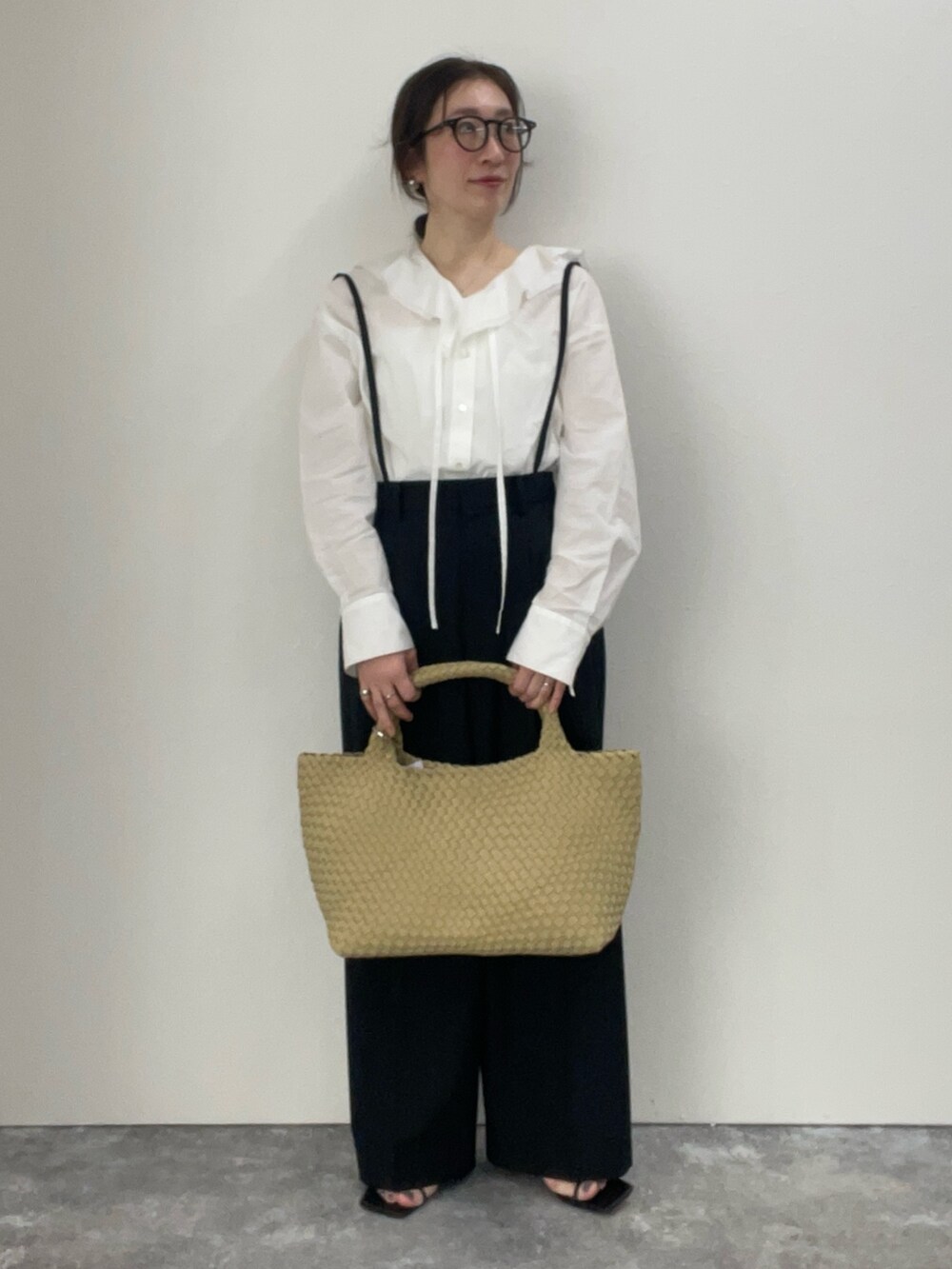 ホワイト系のシャツ/ブラウス、ブラック系のその他パンツ、ベージュ系のトートバッグを着用したレディースの冬コーディネートの2枚目の写真