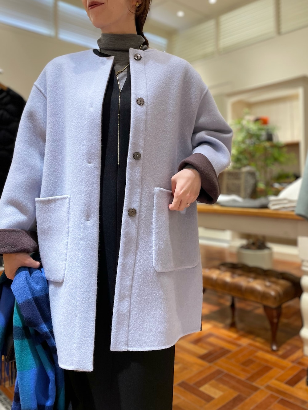 ブラウン系のノーカラーコート、ブラック系のワンピース、グレー系のニット/セーターを着用したレディースの冬コーディネートの8枚目の写真