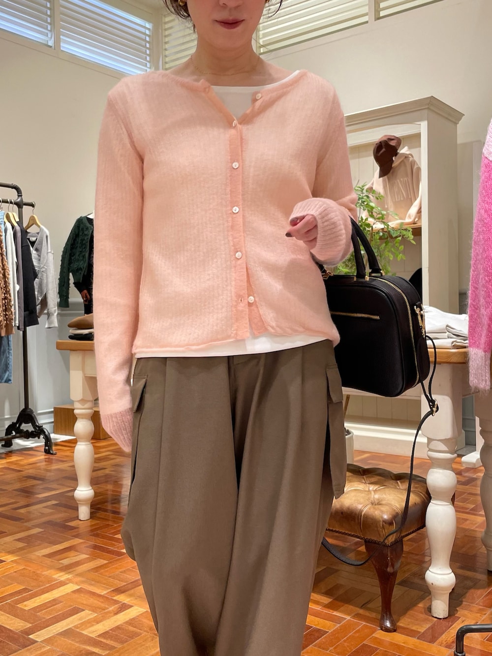 ピンク系のカーディガン/ボレロ、ホワイト系のTシャツ/カットソー、ブラック系のボストンバッグを着用したレディースの秋コーディネートの2枚目の写真