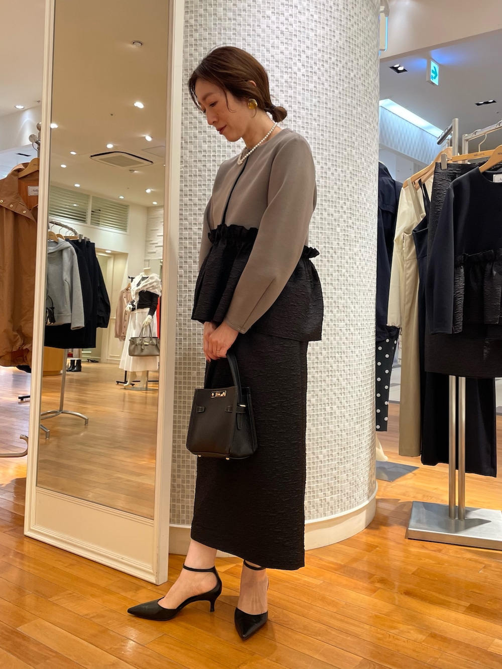 グリーン系のブルゾン、ブラック系のスカート、ブラック系のショルダーバッグを着用したレディースの秋コーディネートの3枚目の写真