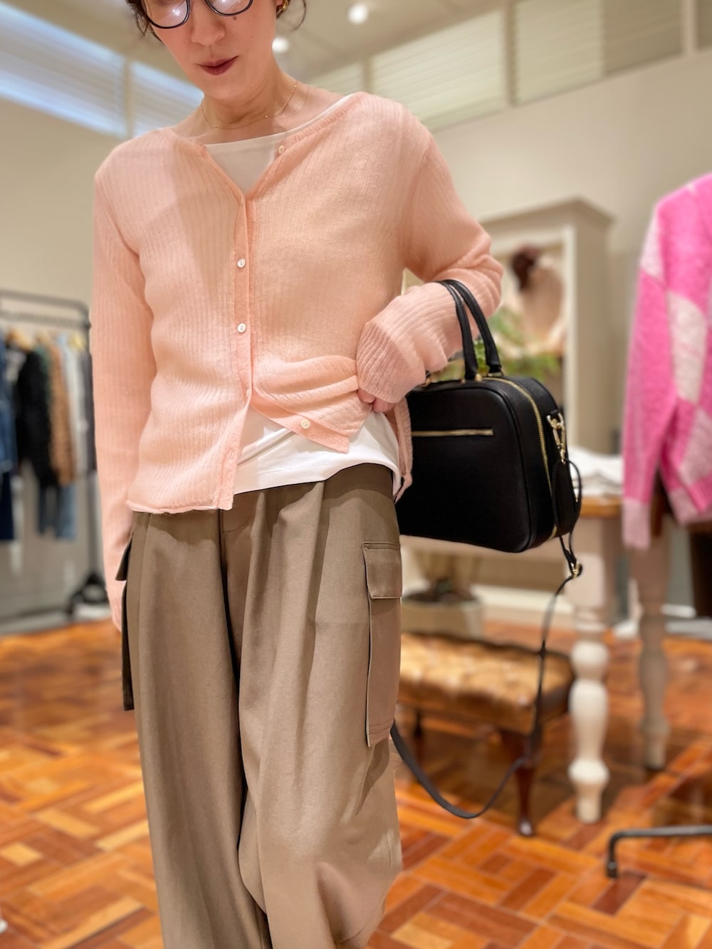 ピンク系のカーディガン/ボレロ、ホワイト系のTシャツ/カットソー、ブラック系のボストンバッグを着用したレディースの秋コーディネートの3枚目の写真