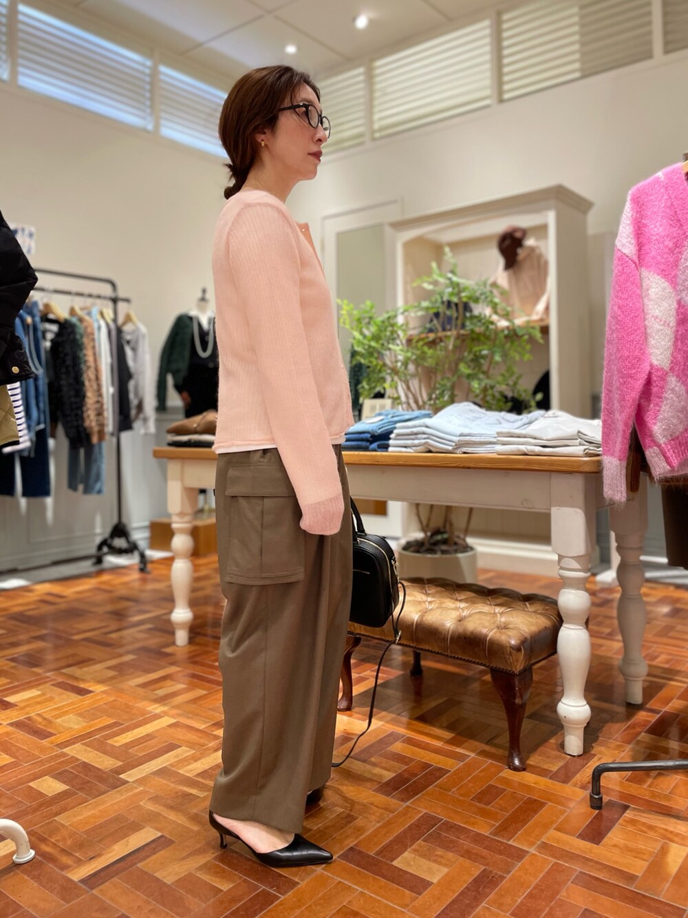 ピンク系のカーディガン/ボレロ、ホワイト系のTシャツ/カットソー、ブラック系のボストンバッグを着用したレディースの秋コーディネートの4枚目の写真