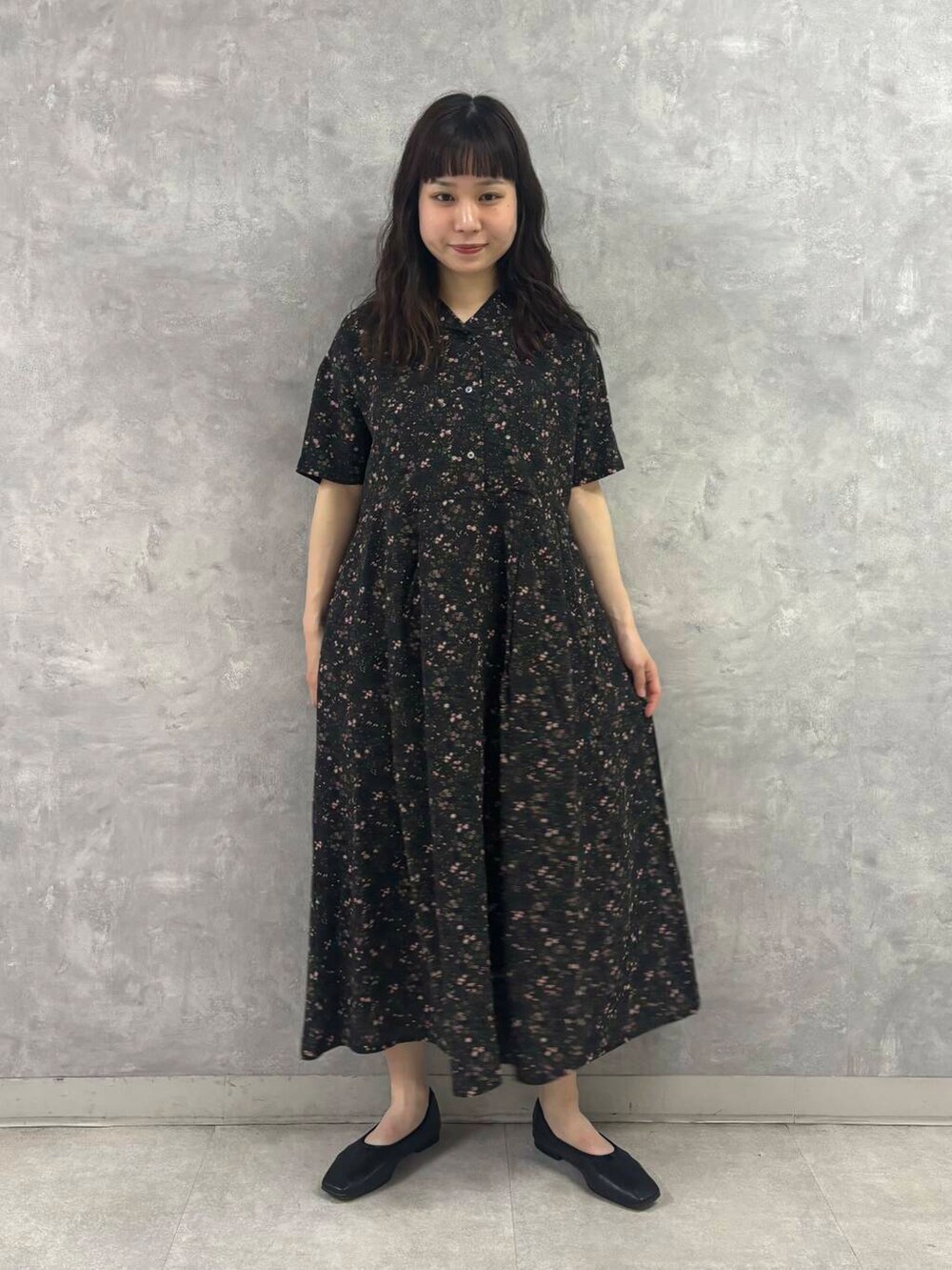 ブラック系のバレエシューズ、ブラック系のショルダーバッグ、グレー系のワンピースを着用したレディースの春コーディネートの3枚目の写真