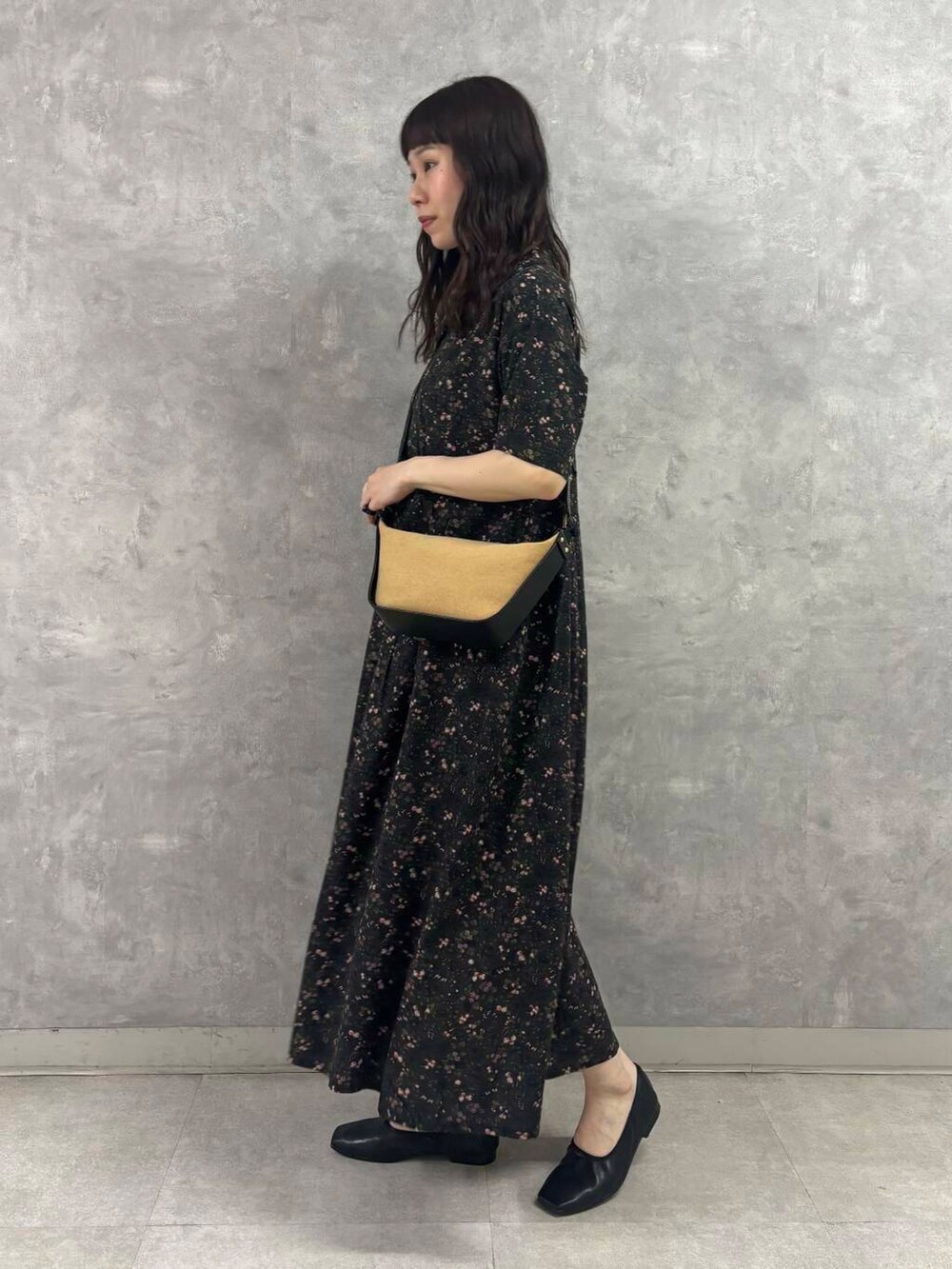 ブラック系のバレエシューズ、ブラック系のショルダーバッグ、グレー系のワンピースを着用したレディースの春コーディネートの2枚目の写真