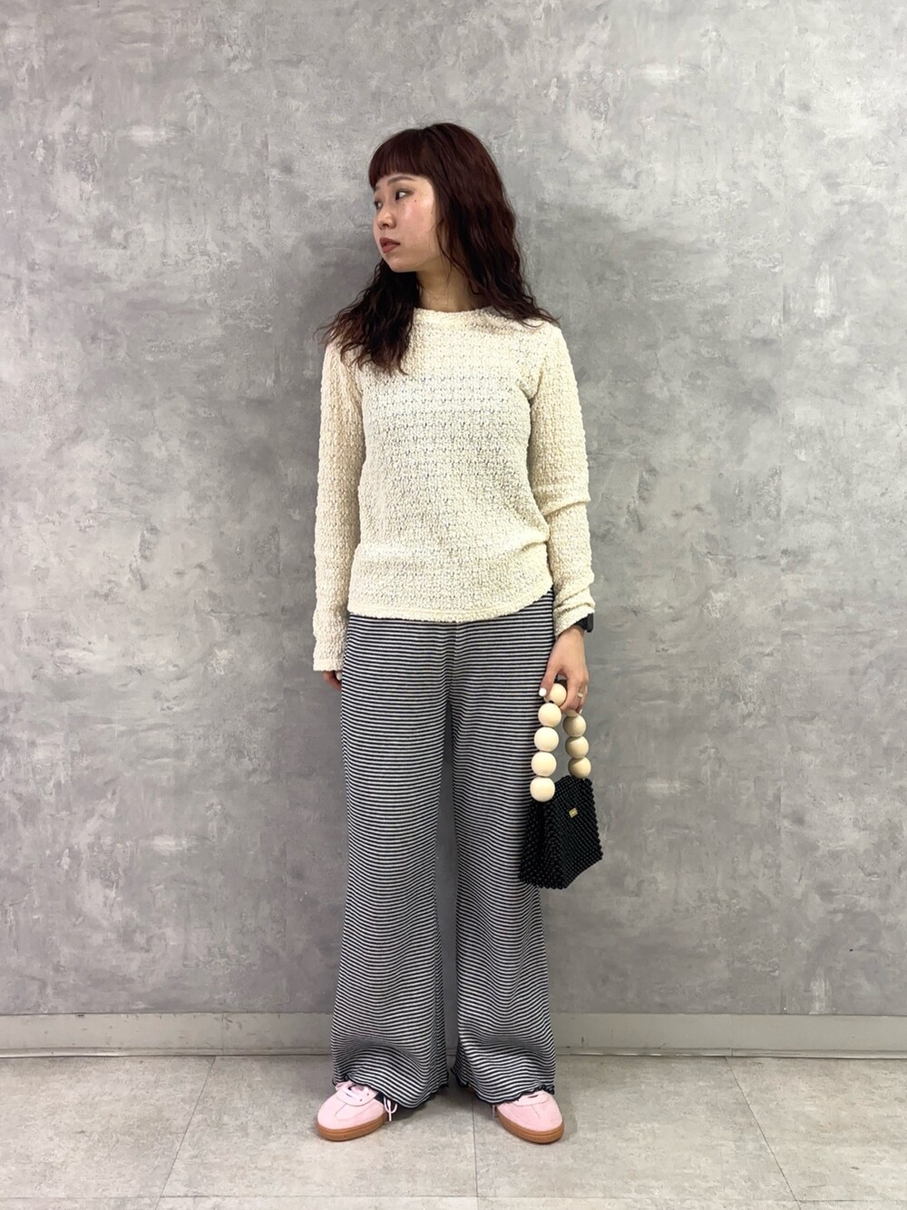 ブラック系のハンドバッグ、ピンク系のスニーカー、ブルー系のその他パンツを着用したレディースの冬コーディネートの2枚目の写真