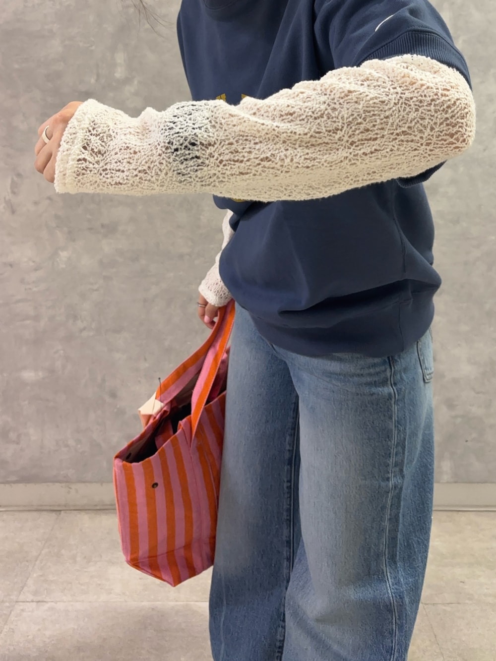 ピンク系のトートバッグ、ブルー系のデニムパンツ、ホワイト系のTシャツ/カットソーを着用したレディースの春コーディネートの4枚目の写真