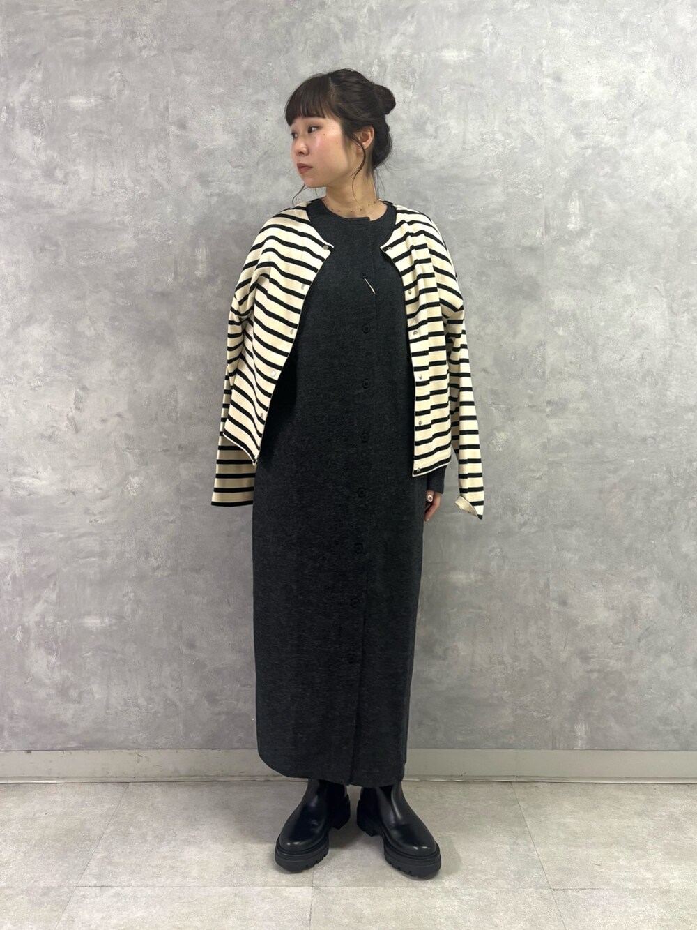 ブラック系のブーツ、ホワイト系のトートバッグ、グレー系のワンピースを着用したレディースの秋コーディネートの3枚目の写真