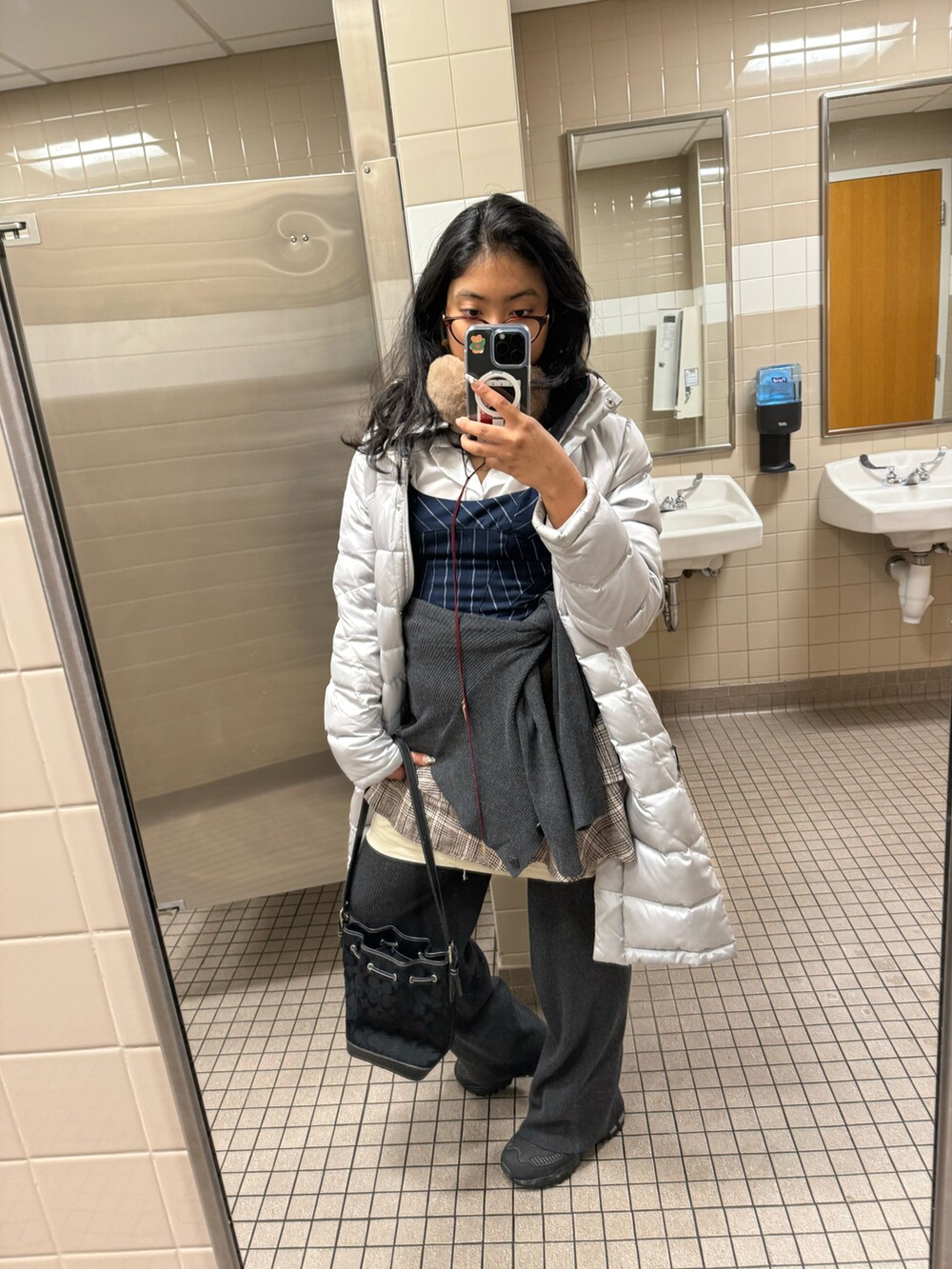 グレー系のダウンジャケット/コート、ブルー系のベスト、ホワイト系のシャツ/ブラウスを着用したレディースの冬コーディネートの2枚目の写真