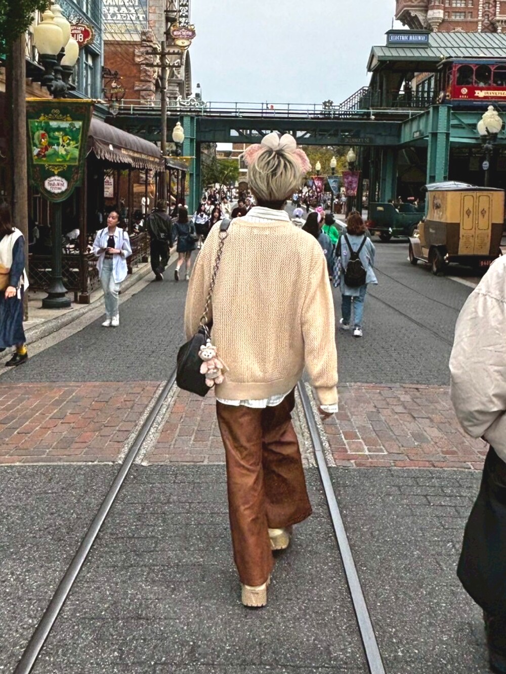 ベージュ系のニット/セーター、ホワイト系のシャツ/ブラウス、ベージュ系のスニーカーを着用したメンズの春コーディネートの2枚目の写真