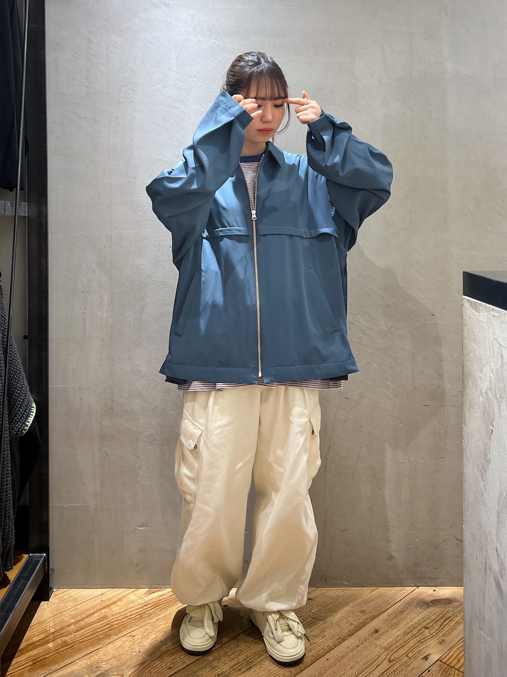 ホワイト系のカーゴパンツ、ブルー系のブルゾン、ブルー系のTシャツ/カットソーを着用したレディースの春コーディネートの3枚目の写真