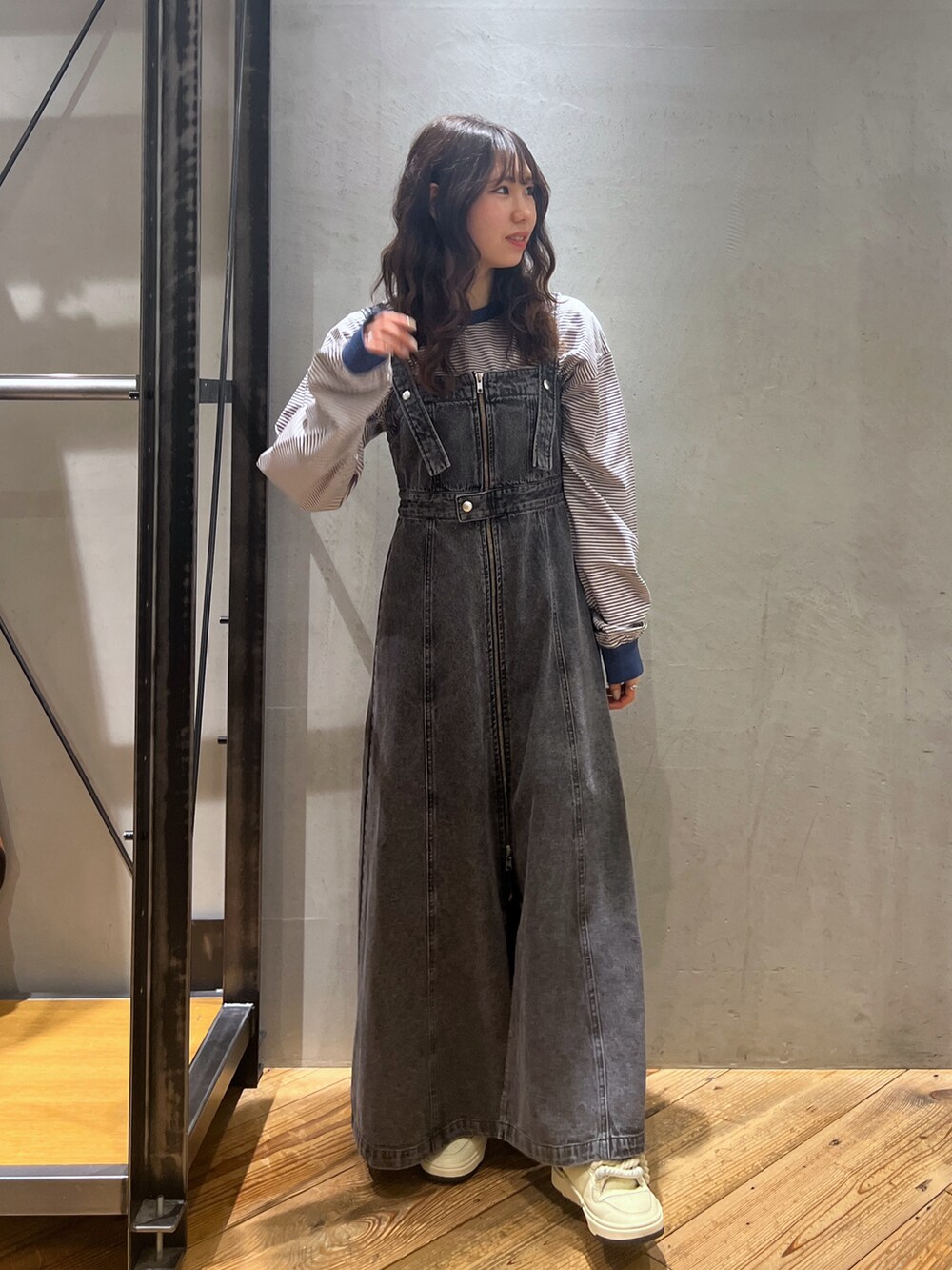 ブラック系のジャンパースカート、ブルー系のトップスを着用したレディースの春コーディネートの3枚目の写真