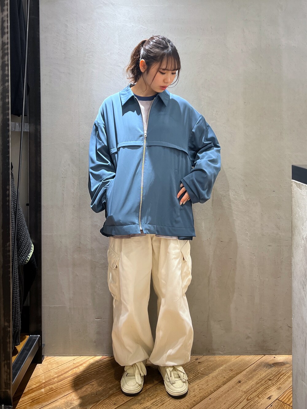 ホワイト系のカーゴパンツ、ブルー系のブルゾン、ブルー系のTシャツ/カットソーを着用したレディースの春コーディネートの2枚目の写真