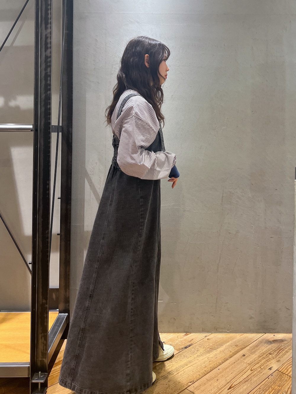 ブラック系のジャンパースカート、ブルー系のトップスを着用したレディースの春コーディネートの4枚目の写真