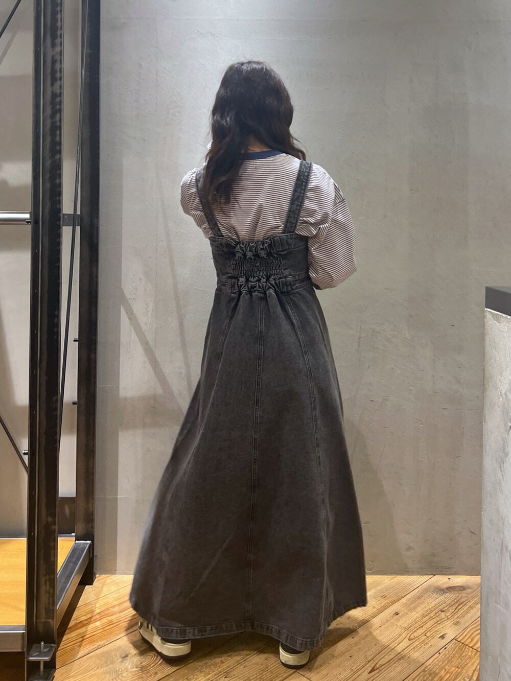 ブラック系のジャンパースカート、ブルー系のトップスを着用したレディースの春コーディネートの5枚目の写真