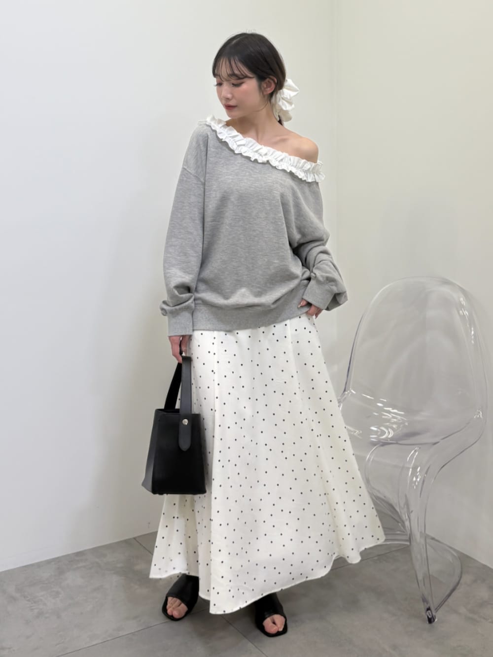 グレー系のスウェット、ホワイト系のスカートを着用したレディースの冬コーディネートの2枚目の写真