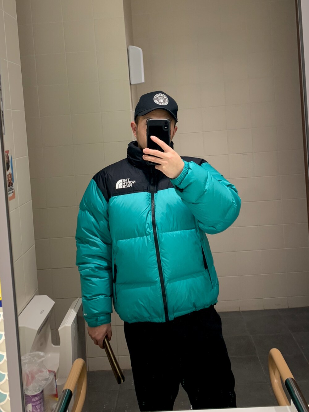 グリーン系のダウンジャケット/コート、ブラック系のパーカー、ブラック系のカーゴパンツを着用したメンズの冬コーディネートの4枚目の写真