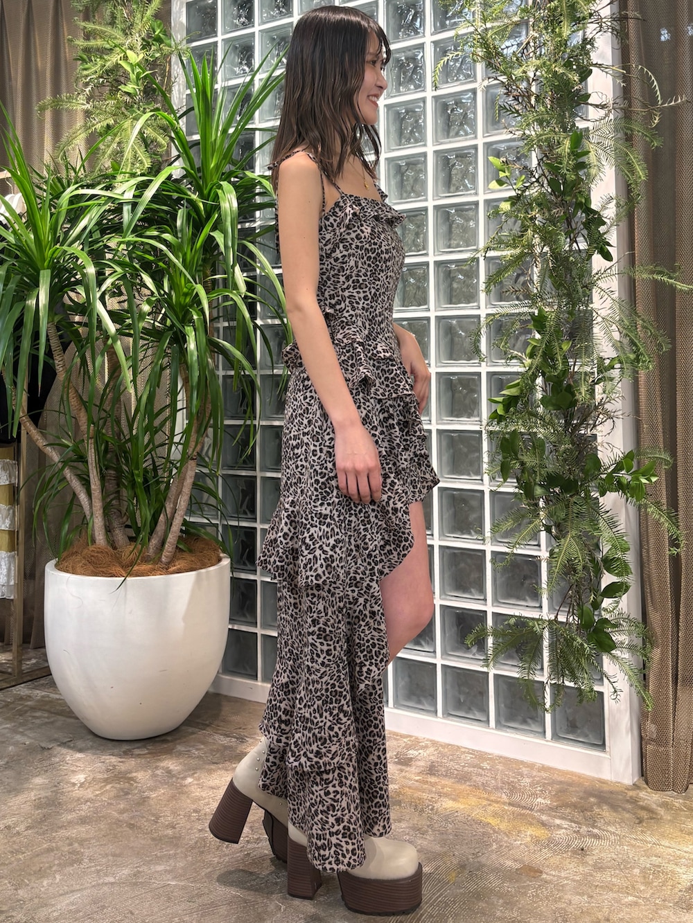 ベージュ系のワンピース、ホワイト系のブーツを着用したレディースの春コーディネートの2枚目の写真