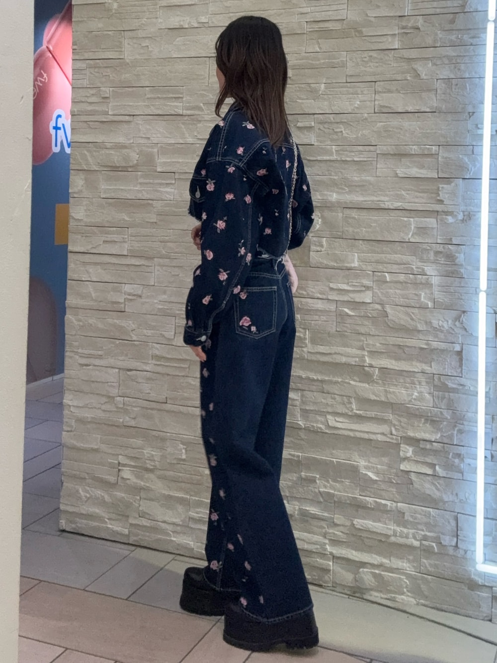 ブルー系のデニムジャケット、ブルー系のデニムパンツ、ブラック系のブーツを着用したレディースの冬コーディネートの2枚目の写真