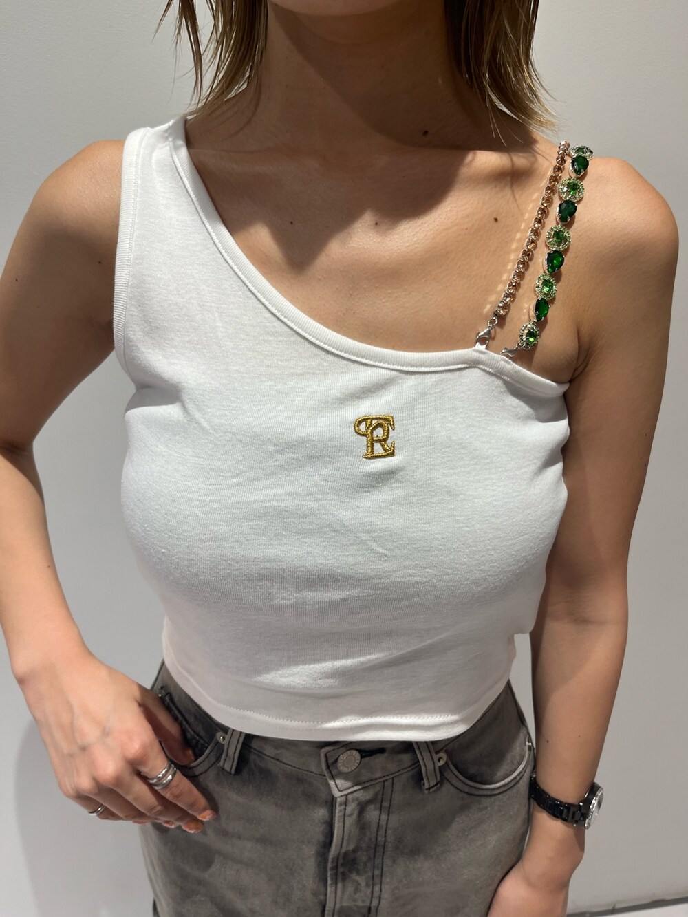 ホワイト系のタンクトップ、ブラック系のデニムパンツ、ブラック系のサンダルを着用したレディースの夏コーディネートの2枚目の写真