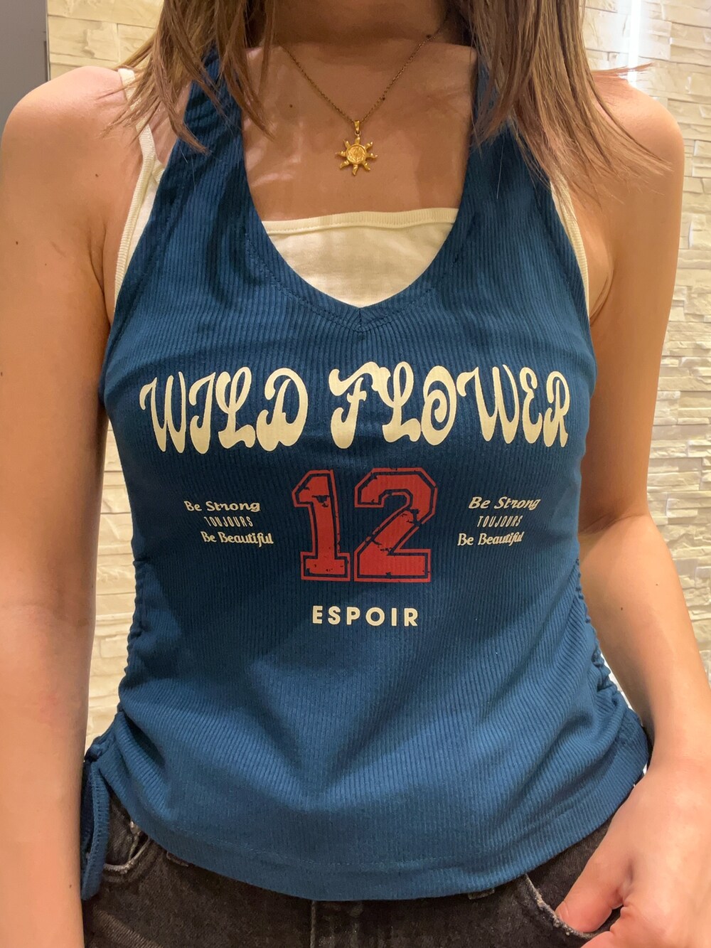 ブルー系のタンクトップ、ブラック系のデニムパンツ、グリーン系のサンダルを着用したレディースの春コーディネートの4枚目の写真