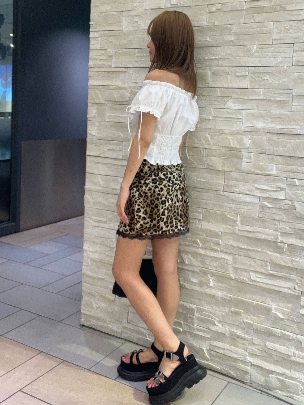 ホワイト系のシャツ/ブラウス、ベージュ系のスカート、ブラック系のサンダルを着用したレディースの夏コーディネートの2枚目の写真