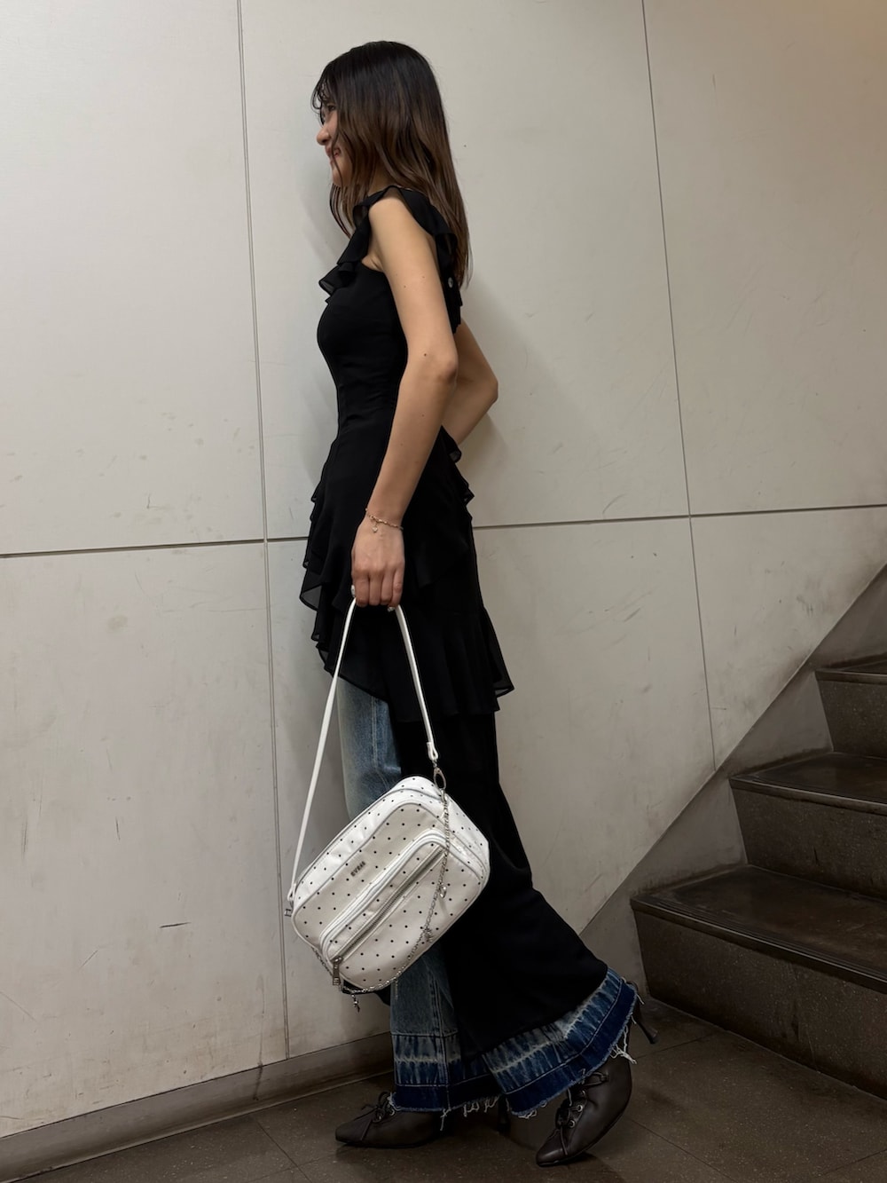 ブラック系のワンピース、ホワイト系のハンドバッグ、ブラック系のサンダルを着用したレディースの春コーディネートの2枚目の写真