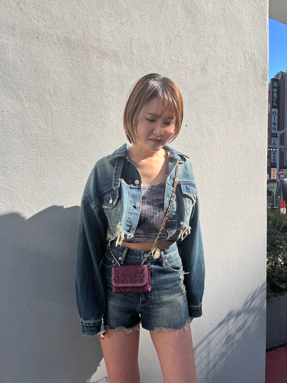 ブルー系のデニムジャケット、ブルー系のデニムパンツ、ピンク系のショルダーバッグを着用したレディースの冬コーディネートの4枚目の写真