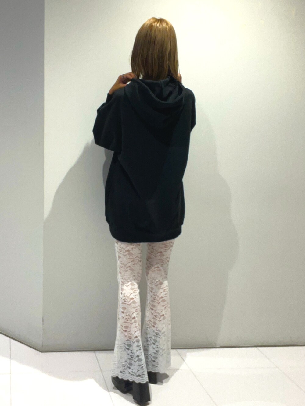 ブラック系のパーカー、ブルー系のハンドバッグ、ホワイト系のその他パンツを着用したレディースの秋コーディネートの3枚目の写真