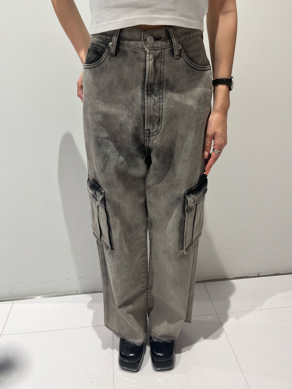 ホワイト系のタンクトップ、ブラック系のデニムパンツ、ブラック系のサンダルを着用したレディースの夏コーディネートの3枚目の写真