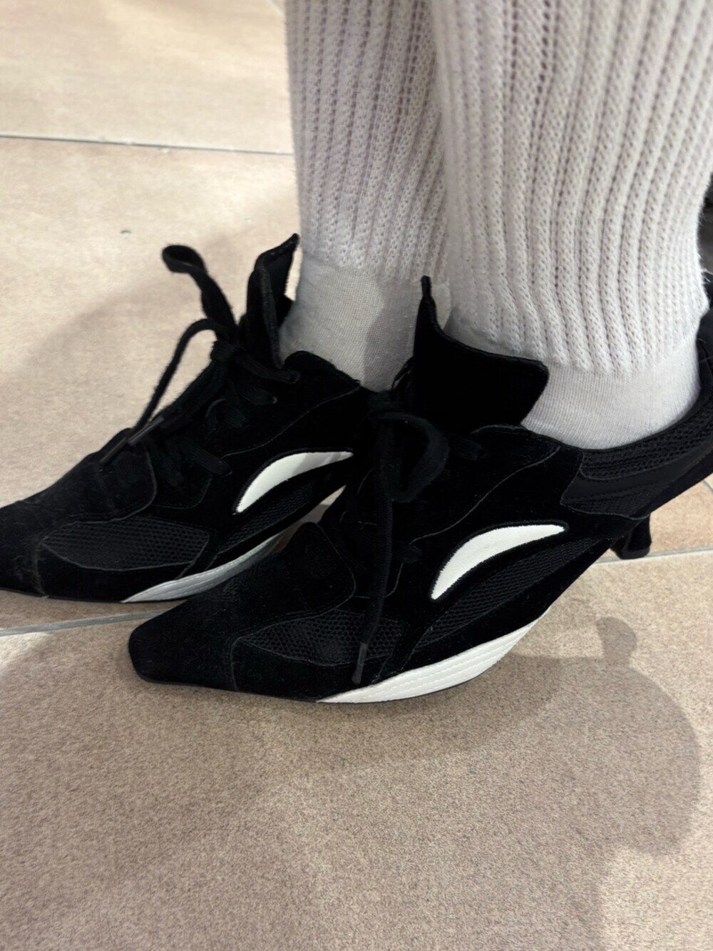 レッド系のニット/セーター、ブルー系のデニムパンツ、ブラック系のパンプスを着用したレディースの秋コーディネートの5枚目の写真