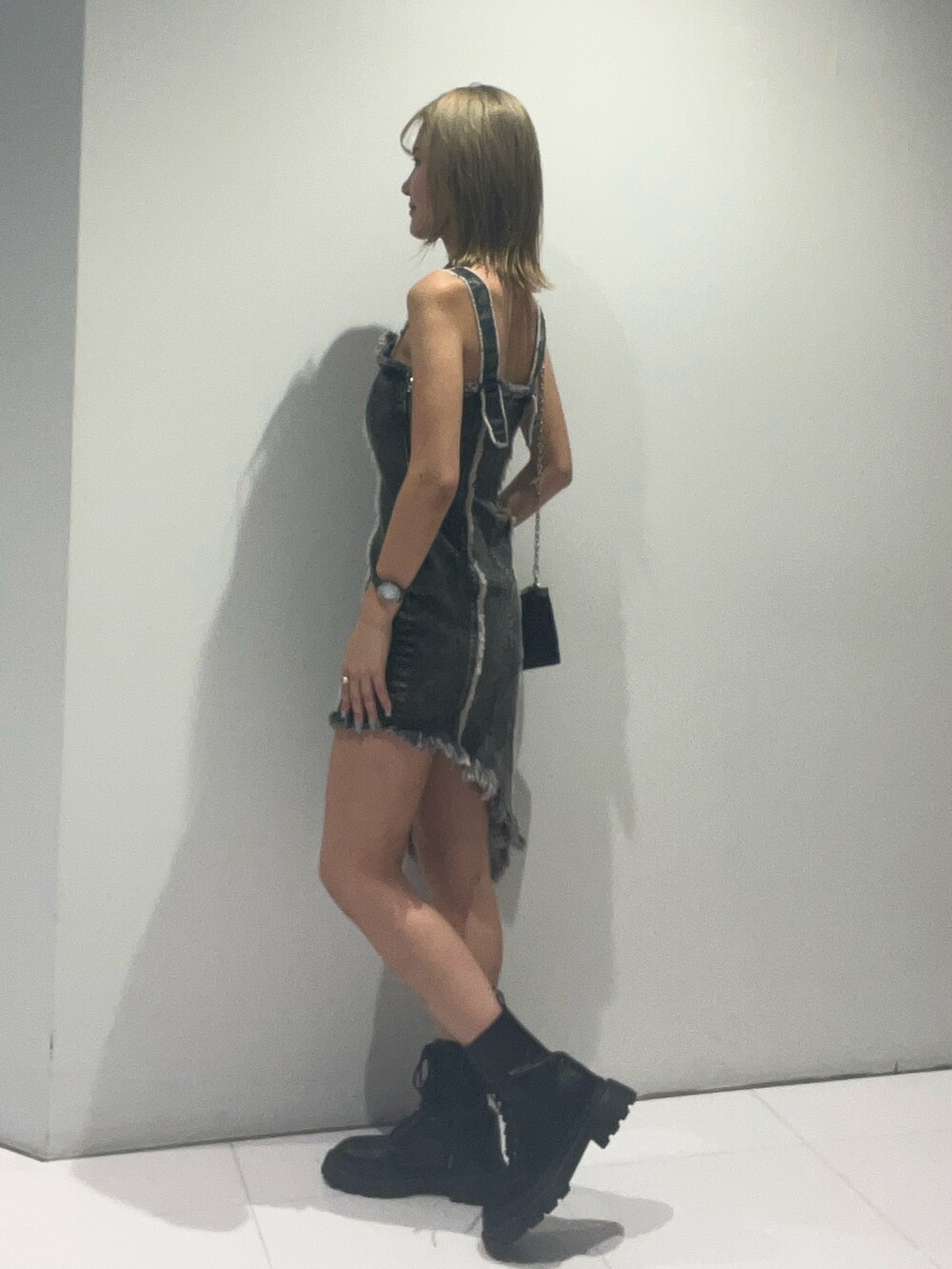 ブラック系のワンピース、ブラック系のショルダーバッグ、ブラック系のブーツを着用したレディースの夏コーディネートの2枚目の写真