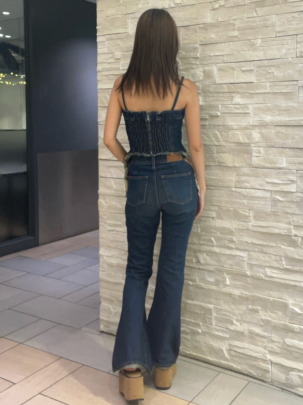 ブルー系のキャミソール、ブルー系のデニムパンツ、ベージュ系のサンダルを着用したレディースの夏コーディネートの3枚目の写真