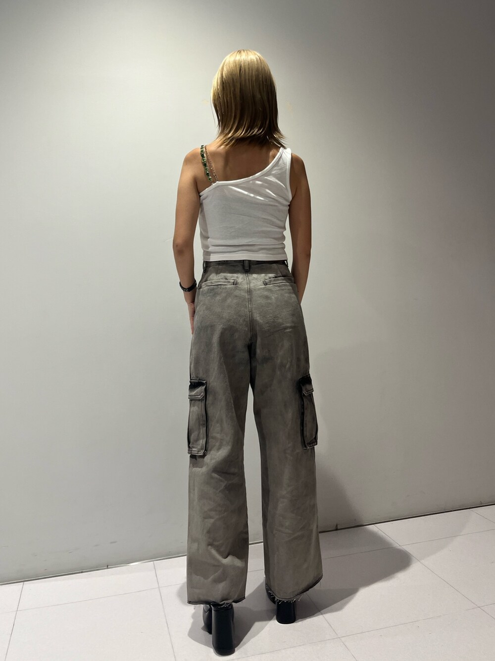 ホワイト系のタンクトップ、ブラック系のデニムパンツ、ブラック系のサンダルを着用したレディースの夏コーディネートの5枚目の写真