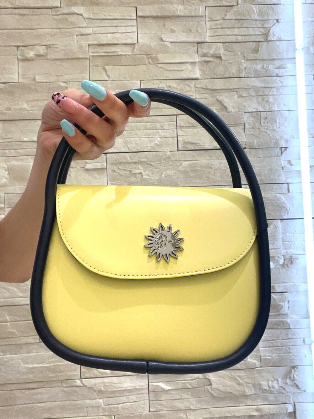 ブルー系のTシャツ/カットソー、ブルー系のデニムパンツ、イエロー系のハンドバッグを着用したレディースの春コーディネートの7枚目の写真