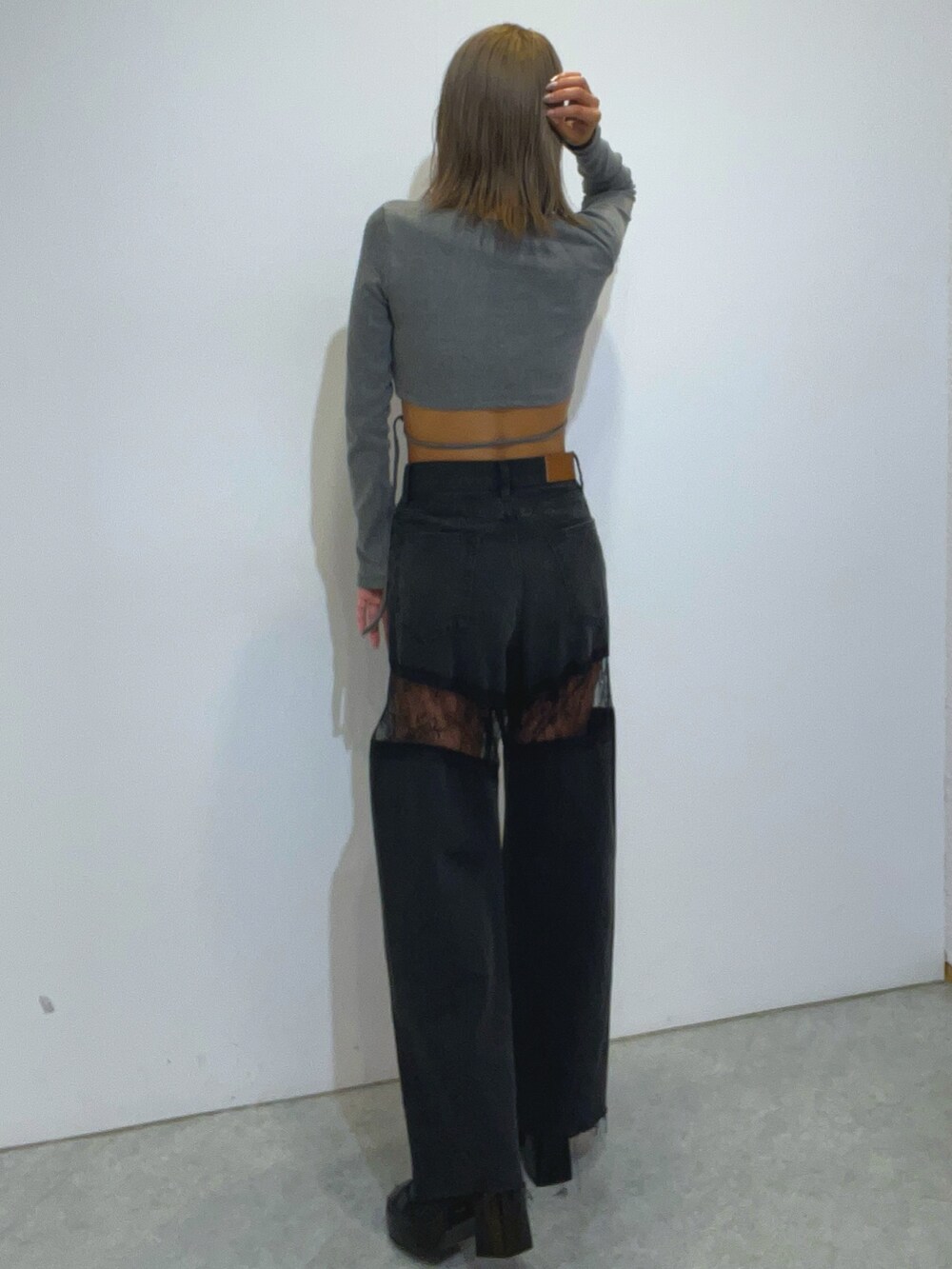 グレー系のTシャツ/カットソー、ブラック系のデニムパンツ、ブラック系のブーツを着用したレディースの秋コーディネートの3枚目の写真