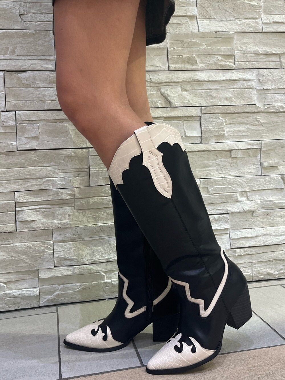 ブラック系のワンピース、ホワイト系のショルダーバッグ、その他のブーツを着用したレディースの冬コーディネートの6枚目の写真