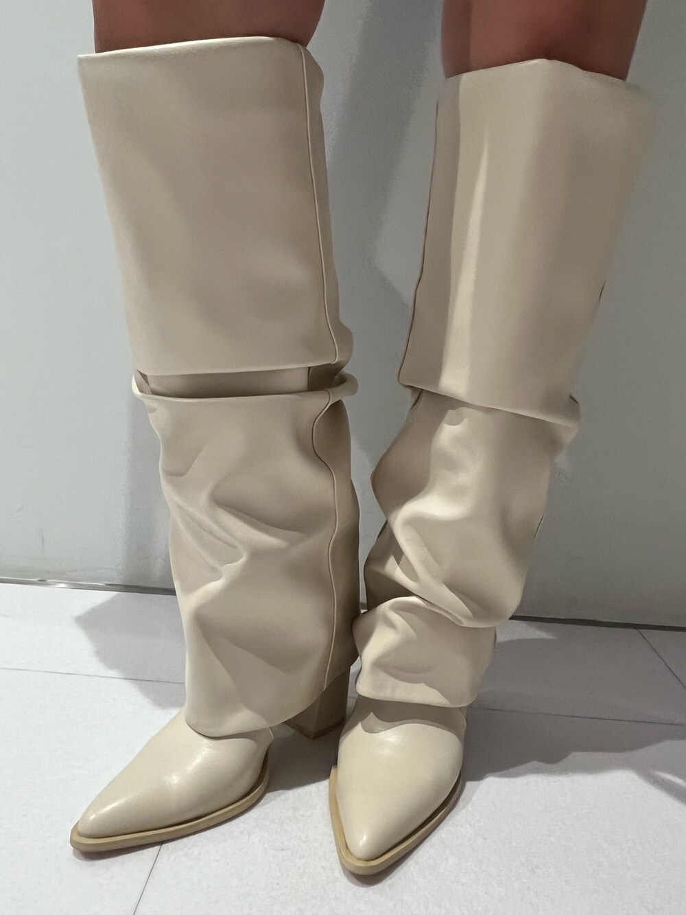 ブルー系のシャツ/ブラウス、ブラック系のショルダーバッグ、ホワイト系のブーツを着用したレディースの春コーディネートの5枚目の写真