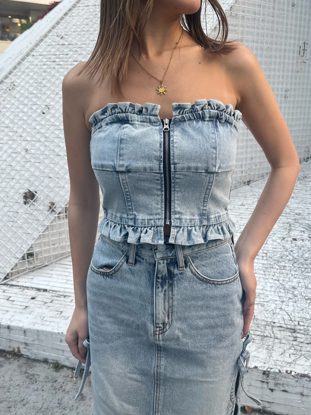 ブルー系のデニムジャケット、ブルー系のチューブトップ、ブルー系のデニムスカートを着用したレディースの冬コーディネートの7枚目の写真