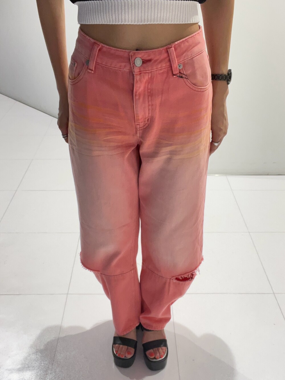 ブラック系のタンクトップ、ピンク系のデニムパンツ、ブラック系のサンダルを着用したレディースの夏コーディネートの3枚目の写真