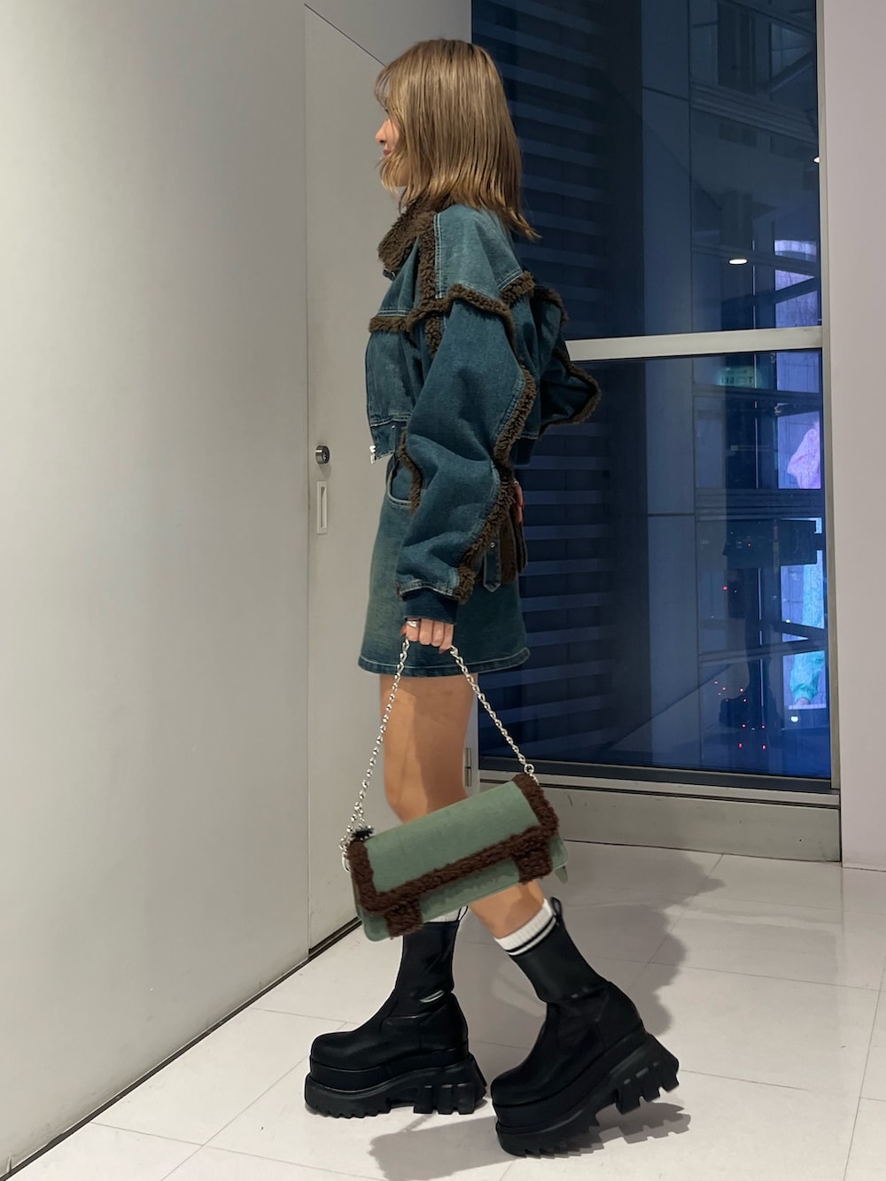 ブルー系のブルゾン、ホワイト系のTシャツ/カットソー、ブルー系のデニムスカートを着用したレディースの秋コーディネートの2枚目の写真