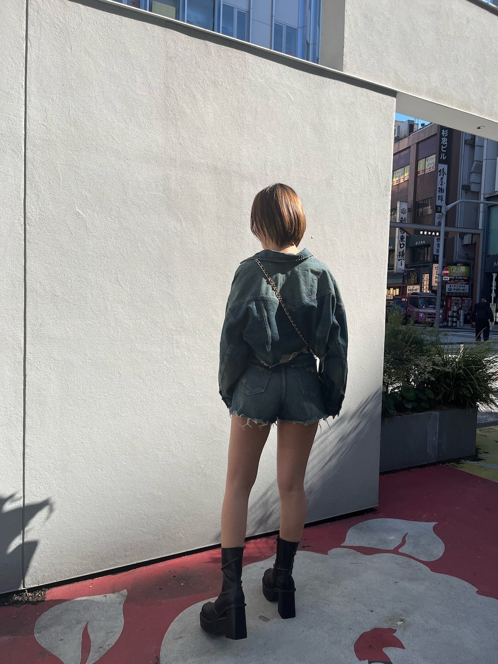 ブルー系のデニムジャケット、ブルー系のデニムパンツ、ピンク系のショルダーバッグを着用したレディースの冬コーディネートの3枚目の写真